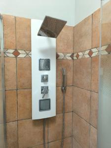 a shower in a bathroom with brown tiles at Villa Grazie Mille - Charming Lake Como Escape in Perledo