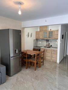a kitchen with a wooden table and a refrigerator at Georges House in Nea Moudania +3 photos