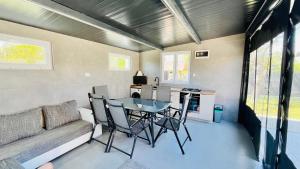 a living room with a table and chairs and a couch at Lebegő Falu Vendégház in Oroszlány +10 photos