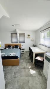a bedroom with a bed and a desk and a table at Lebegő Falu Vendégház in Oroszlány