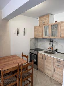 a kitchen with wooden cabinets and a wooden table at Georges House in Nea Moudania
