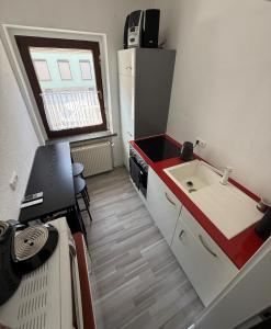 a small kitchen with a sink and a refrigerator at Ruhiges Apartment Meerane in Meerane