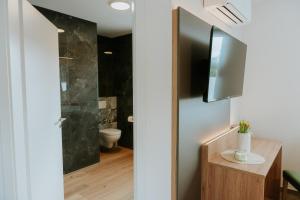 a bathroom with a toilet and a television on a wall at Stay2sleep, Self-Check-In in Dinklage +28 photos