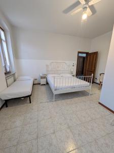 a bedroom with two beds and a ceiling fan at B&B Villa Clara in Dossobuono