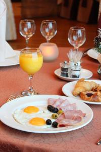 a table with a plate of breakfast food and a glass of orange juice at Alexandrovsky Garden in Nizhny Novgorod