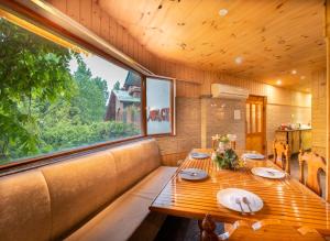 a dining room with a table and a large window at Hotel Mirage in Srinagar