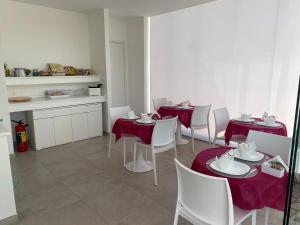 a dining room with red tables and white chairs at Tenuta Verdolivo in Ostuni