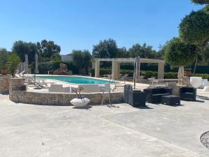 a swimming pool with chairs and umbrellas at Tenuta Verdolivo in Ostuni
