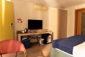 a bedroom with a bed and a desk with a television at Green House Garden Park Hotel in Istanbul