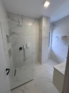 a white bathroom with a shower with a glass door at Hotel Omw Vore in Vorë +38 photos