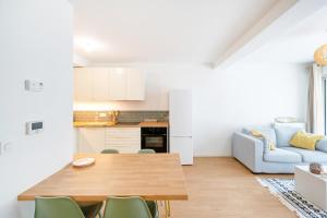 a kitchen and living room with a table and a couch at Appartement proche du port in Capbreton