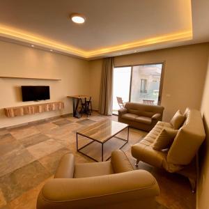 a living room with two couches and a fireplace at Sunshine Resort - Tabarja, Lebanon in An Nā‘ūrah