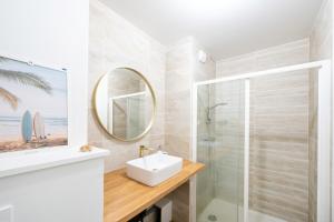 a bathroom with a sink and a shower and a mirror at Appartement proche du port in Capbreton +12 photos