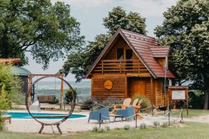 a log cabin with a swing and a playground at Laguna Platz in Sremski Karlovci