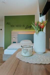 a vase with flowers on a table in a bedroom at Stay2sleep, Self-Check-In in Dinklage