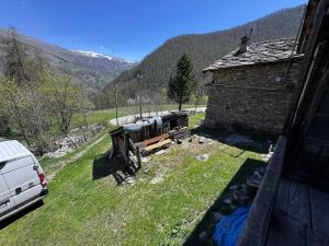 a van parked in a yard next to a building at La Caso dal Chiot - Chalet in Elva