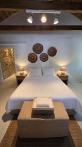 a bedroom with a large white bed with a table at Light & Stone Villa, Kefalonia in Lixouri