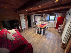 a living room with a red couch and a table at La Caso dal Chiot - Chalet in Elva