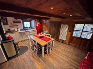 a kitchen with a wooden table and a refrigerator at La Caso dal Chiot - Chalet in Elva