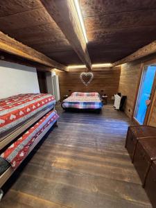 a room with two beds and a heart on the wall at La Caso dal Chiot - Chalet in Elva