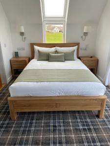 a large bed in a bedroom with a window at Flotnar Hús - Newbuild B&B in Keiss