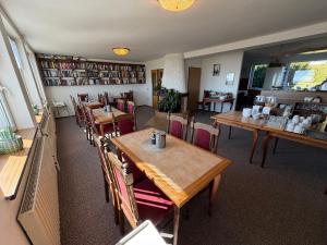 a restaurant with wooden tables and chairs in a room at Penzion V Kolonce in Strážné +35 photos