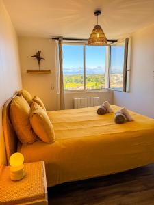 a bedroom with a large yellow bed with a large window at La Tour Myra in Valras-Plage
