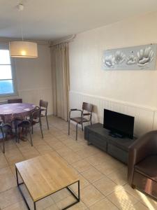 a dining room with a table and chairs and a tv at Hostellerie de Pavillon Saint-Hubert in Gouvieux
