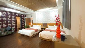 a bedroom with two beds and a table with a vase at 青禾溫泉家民宿 in Jiaoxi +60 photos