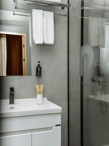 a bathroom with a sink and a shower with a mirror at NOOMA Hotel Frunze in Bishkek +87 photos