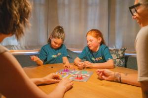 a group of girls playing a game at a table at Haus Berta, Montafon in Partenen