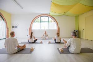 un grupo de personas sentadas en una clase de yoga en Agriturismo Casa Zen, en San Martino Buon Albergo