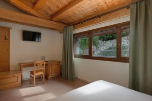 a bedroom with a bed and a desk and a window at Sporting Hotel San Felice in Illasi
