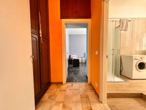 an open hallway with orange walls and a kitchen at La Fenice - Studio Flat in Finale Ligure