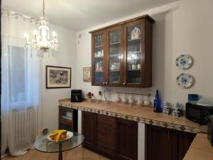 a kitchen with a counter and a glass table at Villa Grazie Mille - Charming Lake Como Escape in Perledo