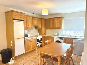 a kitchen with wooden cabinets and a table with chairs at Bay Breeze Hideaway in Cobh
