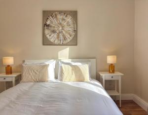 a bedroom with a bed with two tables and two lamps at Bay Breeze Hideaway in Cobh