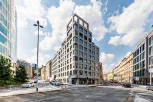 a tall white building on a city street at MamaStay Andel Apartments in Prague
