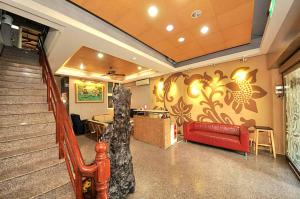 a lobby with a red couch and a staircase at 青禾溫泉家民宿 in Jiaoxi