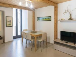 a dining room with a table and chairs and a television at Casa Luna in Tricase