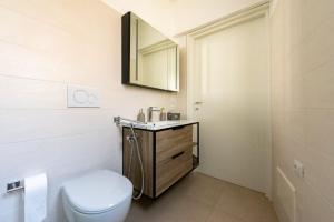 a bathroom with a toilet and a sink and a mirror at Casa Luna in Tricase +8 photos
