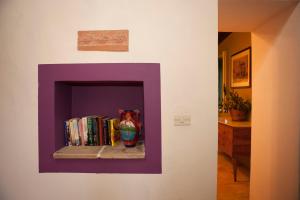 a shelf with books and a vase on a wall at Agriturismo Boccadifuoco sul Fiume Alcantara in Motta Camastra