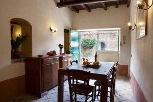 a kitchen with a table and chairs and a window at Agriturismo Boccadifuoco sul Fiume Alcantara in Motta Camastra