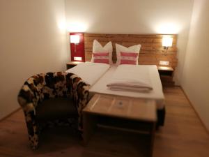 1 dormitorio con cama con almohadas y mesa en Dorfstub'n Jochberg, en Jochberg