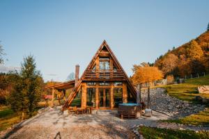 a log cabin in the woods with a large window at Lunor House in Izvoare