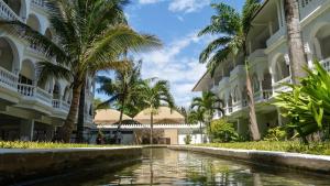a canal in front of a building with palm trees at CityBlue Creekside Hotel & Suites in Mombasa