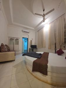 a bedroom with a large bed and a couch at The Wayside Inn in Matheran
