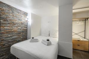 a bedroom with a white bed and a brick wall at Cannes Guest House in Cannes