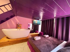 a bathroom with a tub and a bed and a sink at Romance Apartments in Sarandë +290 photos
