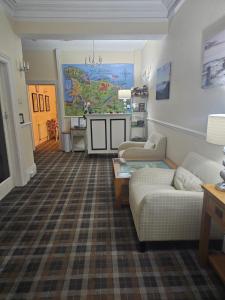 a living room with two couches and a map on the wall at St. Hilary Guest House in Llandudno